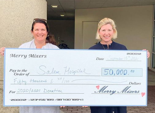 Merry Mixers bringing a donation check to North Shore Medical Center