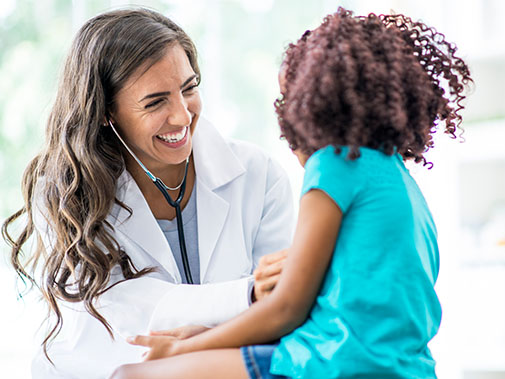 Primary Care Physician laughing with her young patient