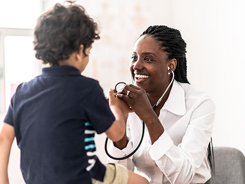 Doctor talking to and treating her young patient
